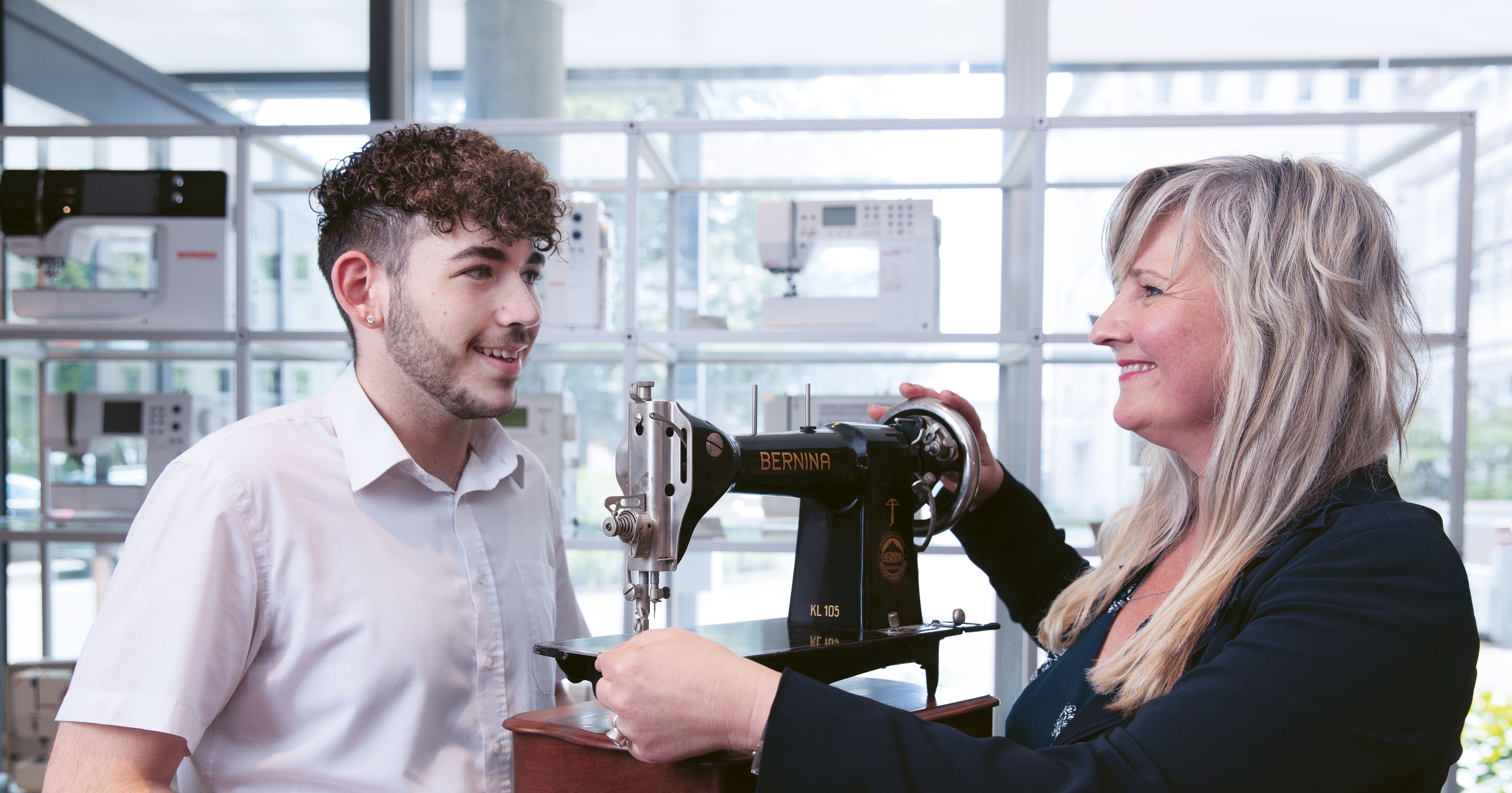 Auf dem Bild sind ein junger Mann und seine Berufsbildnerin an einer Nähmaschine zu sehen. Die Berufsbildnerin hat einen Berufsbildungs-Kurs bei der Swissmem Academy absolviert. 